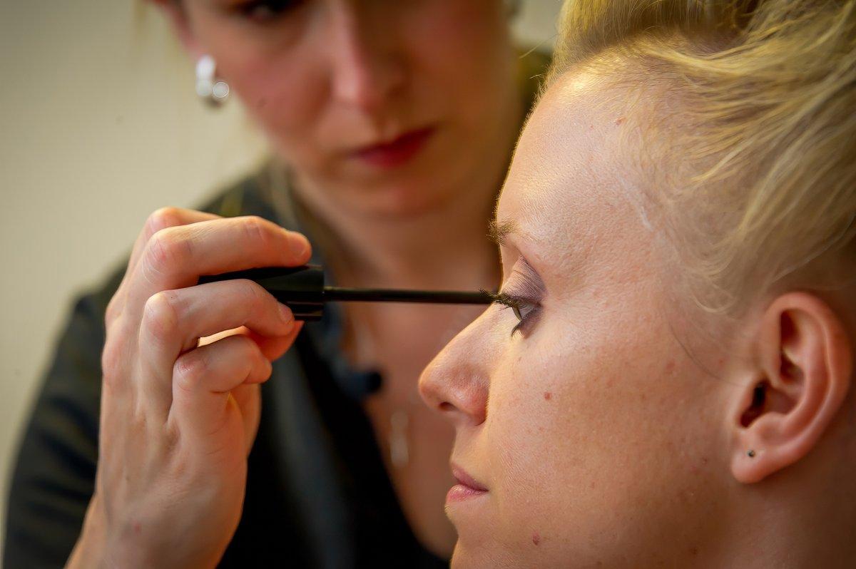 La maquilleuse applique du maquillage sur la mariée