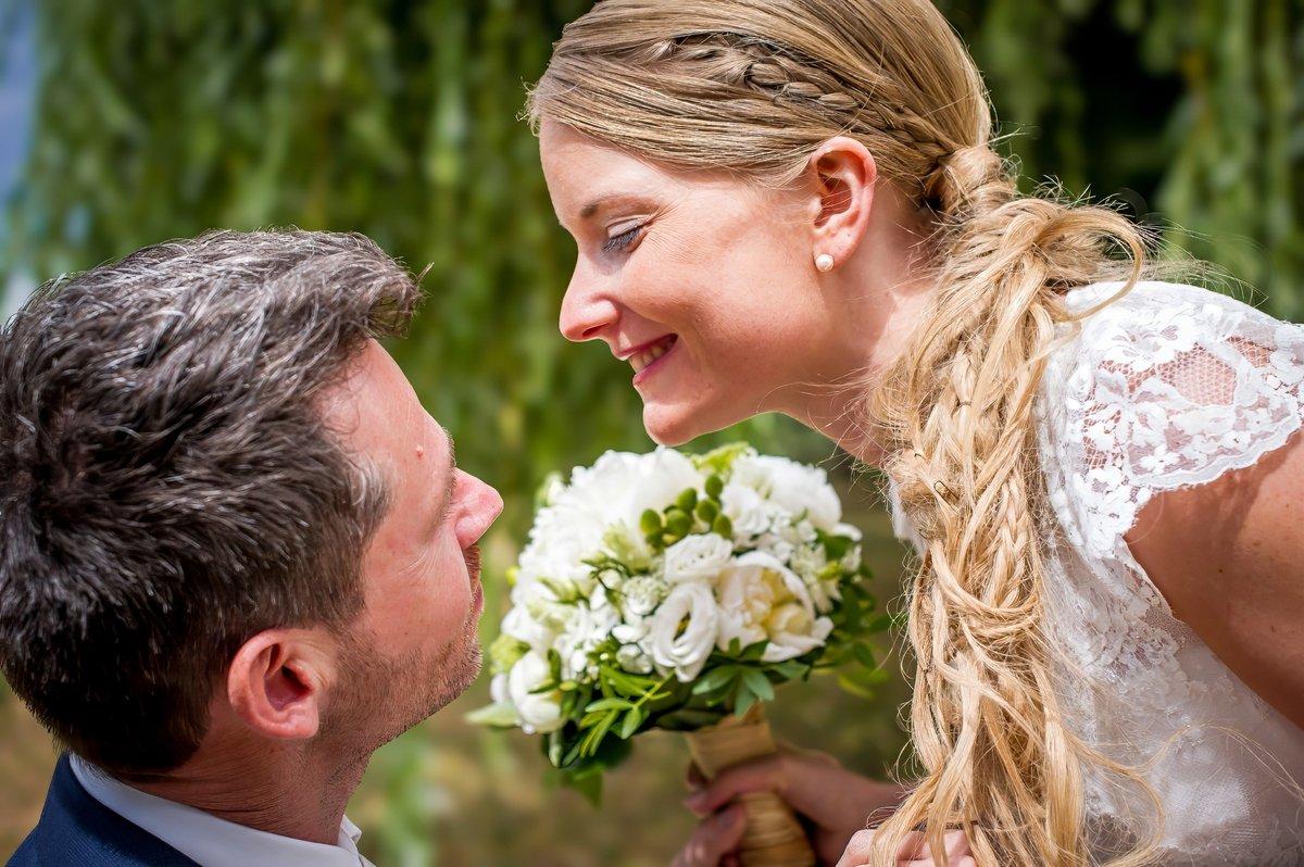 Mariée souriant au marié en tenant un bouquet