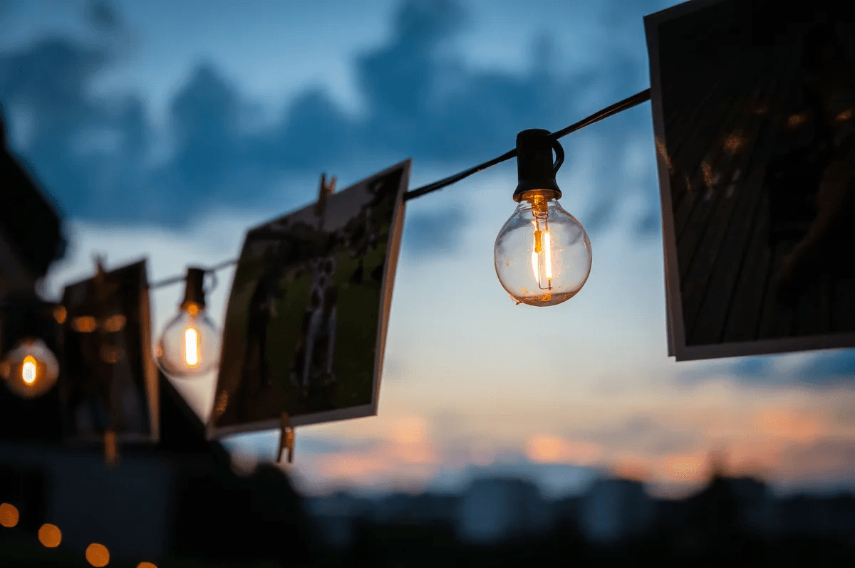 Des photos accrochées avec des lampes illuminées au coucher du soleil