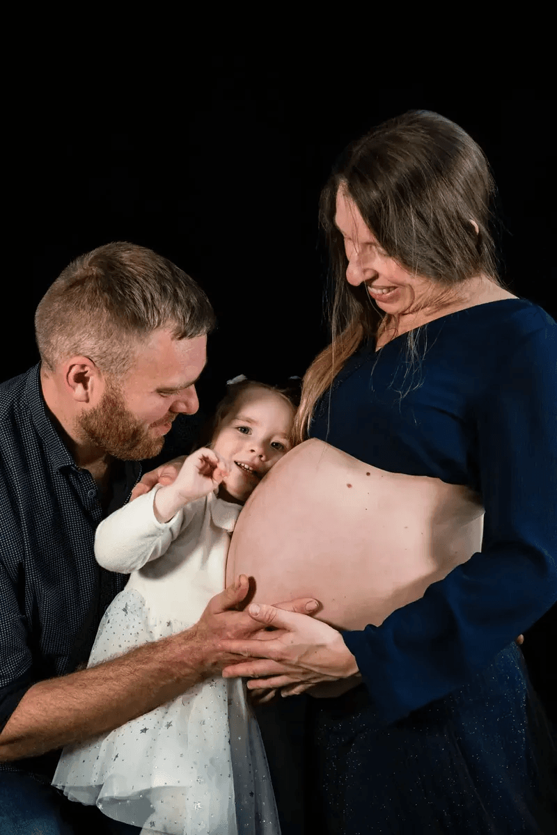 Famille contemplant le ventre de maman enceinte