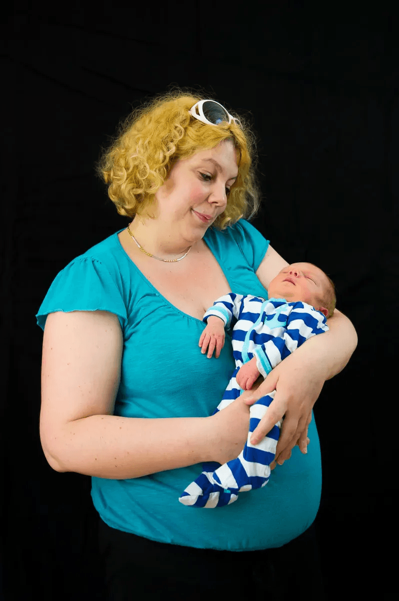 La maman regarde son bébé qui dort dans ses bras