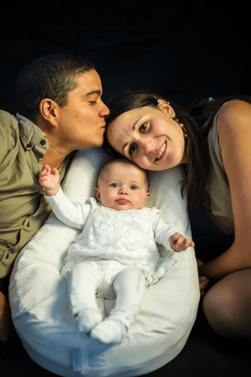 Le papa et la maman sourient avec leur bébé dans un cocon