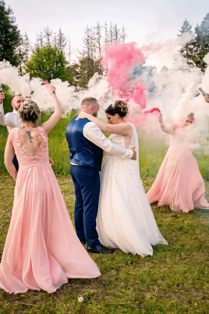 Mariés dansant avec fumigènes blancs et roses