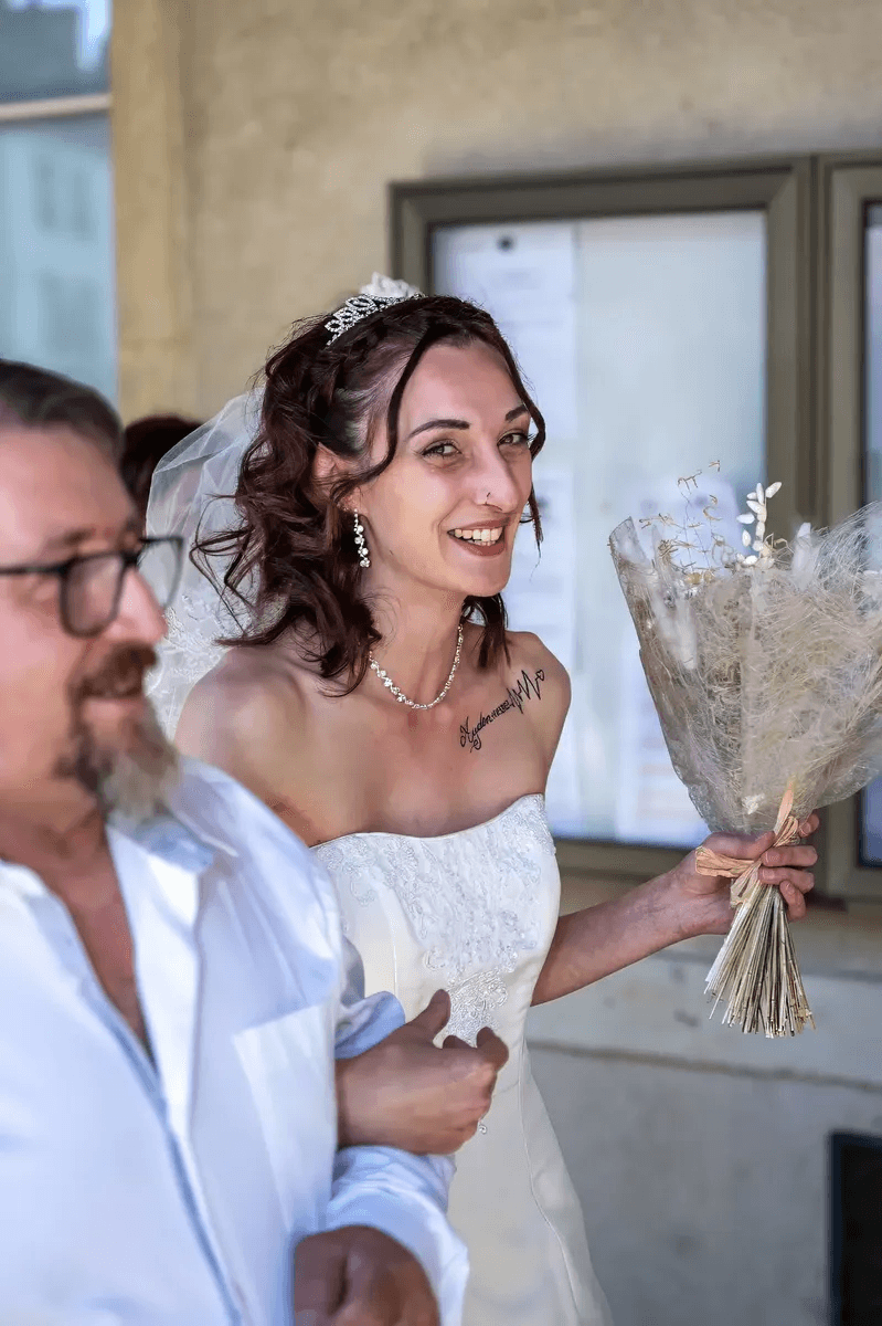 La mariée souriante tenant son bouquet
