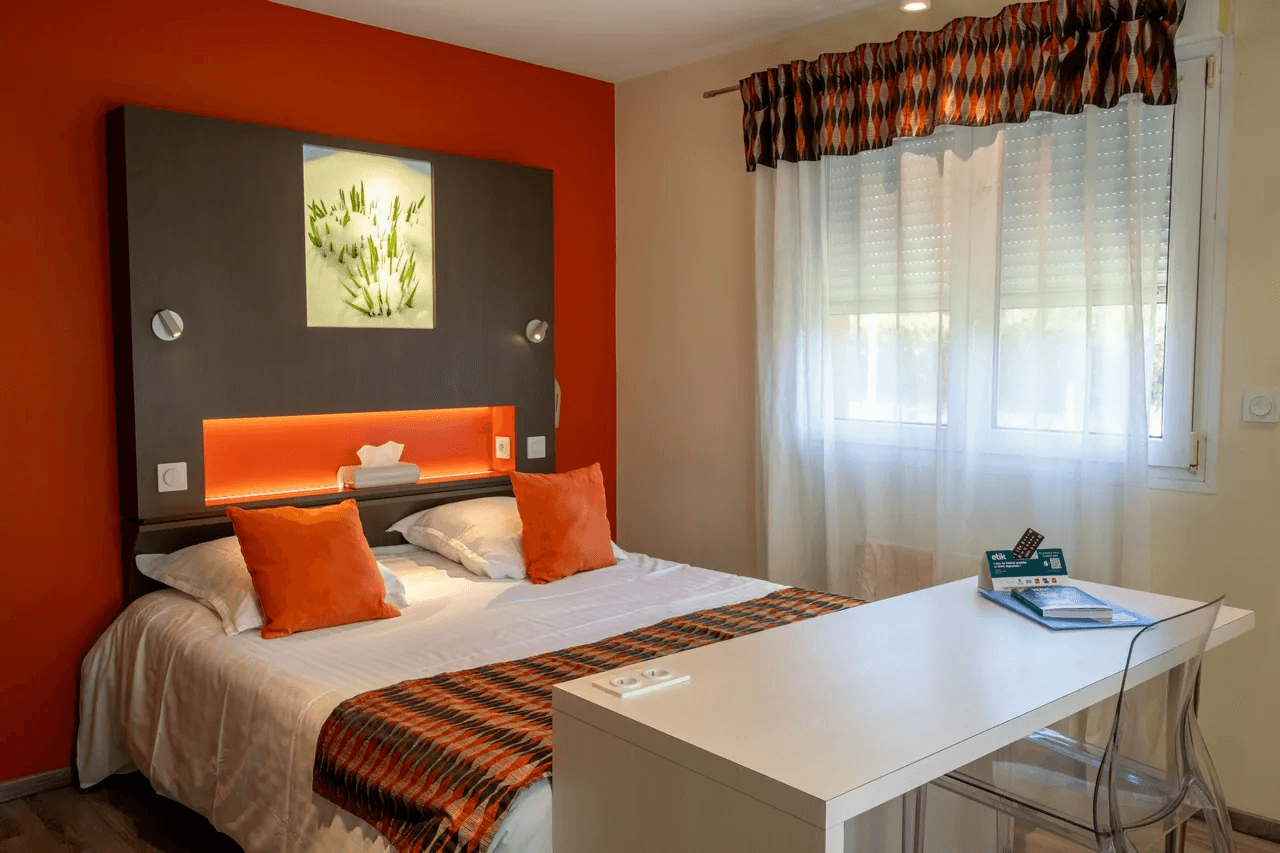 Chambre cosy avec coussins colorés et rideaux