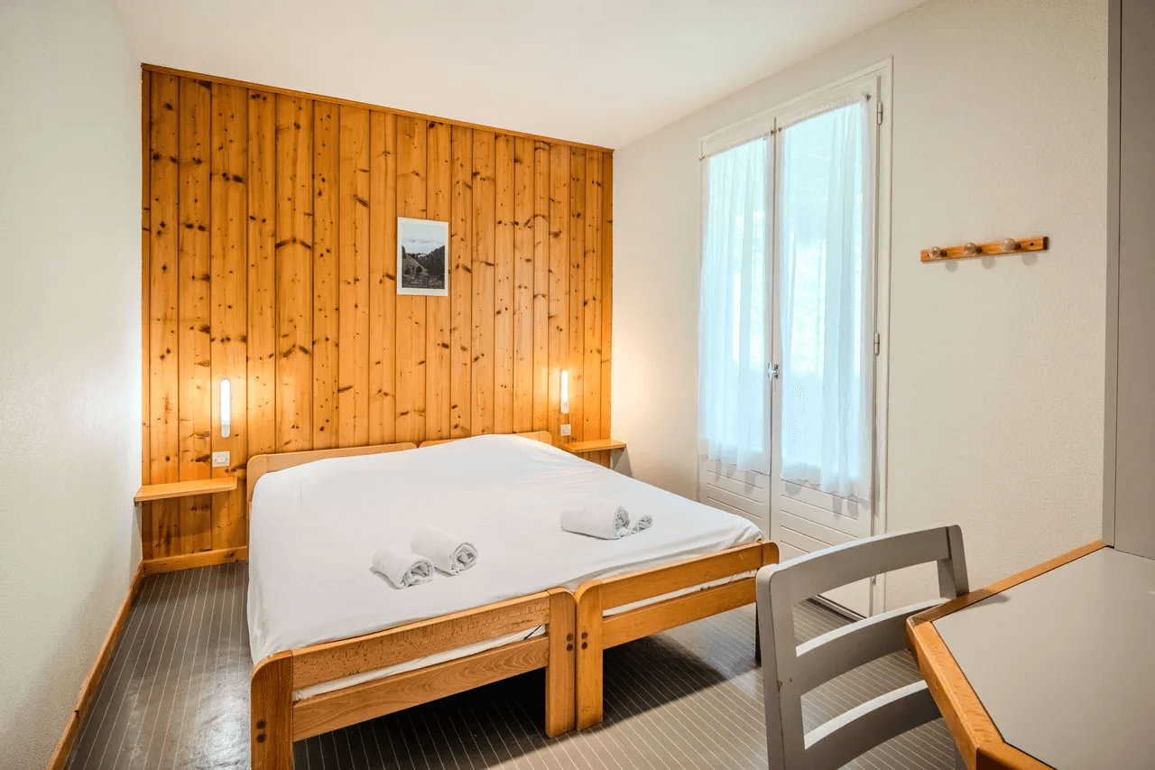 Chambre chaleureuse au lambris bois avec lit double