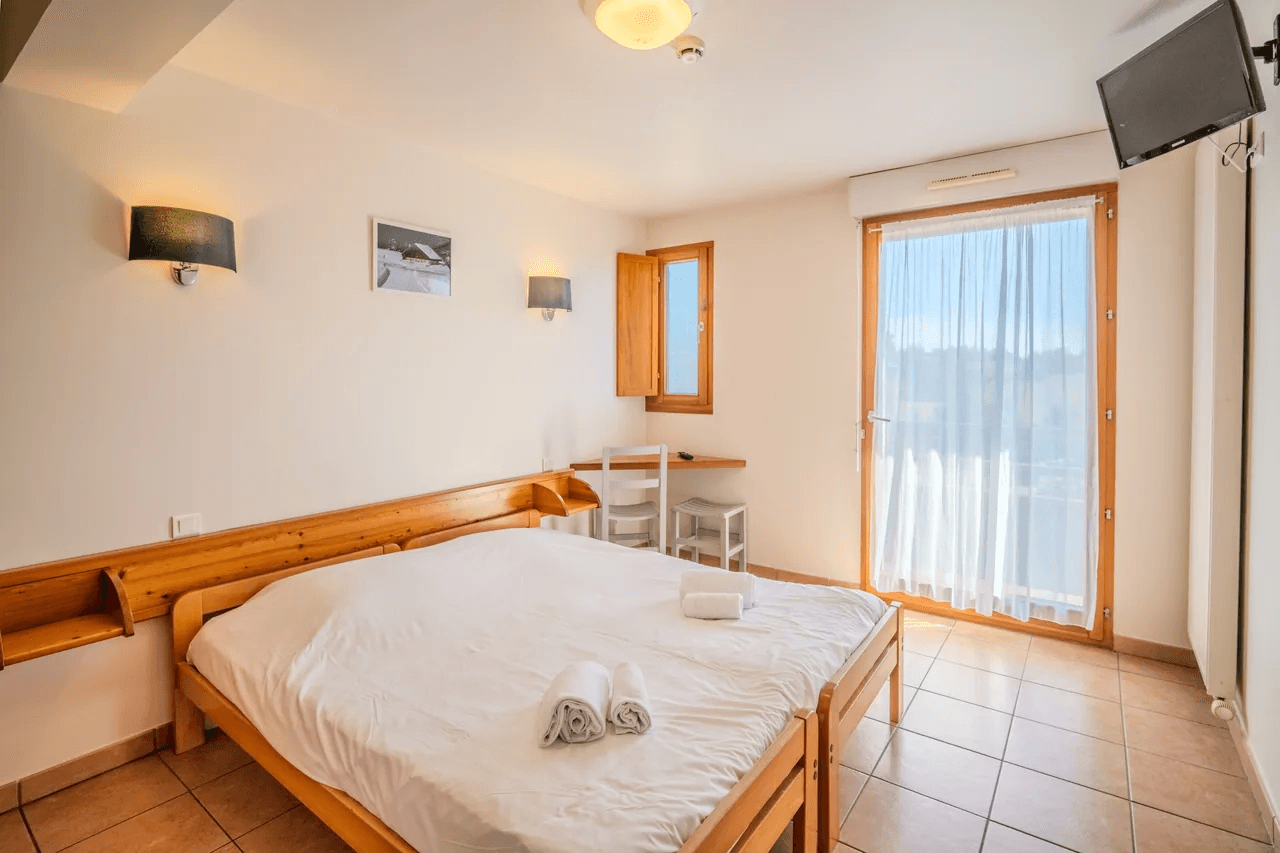 Chambre lumineuse avec lit double et accès balcon — photo pour location saisonnière