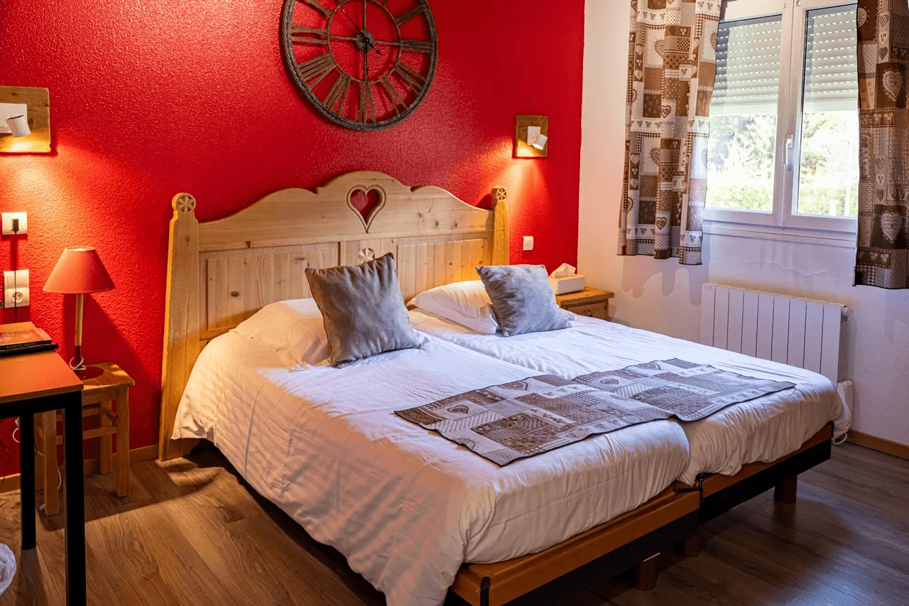 Chambre chaleureuse aux murs rouges avec lit double