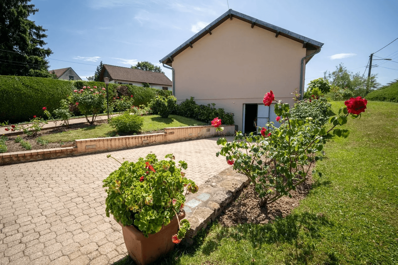 Maison vue extérieure avec jardin fleuri et allée pavée