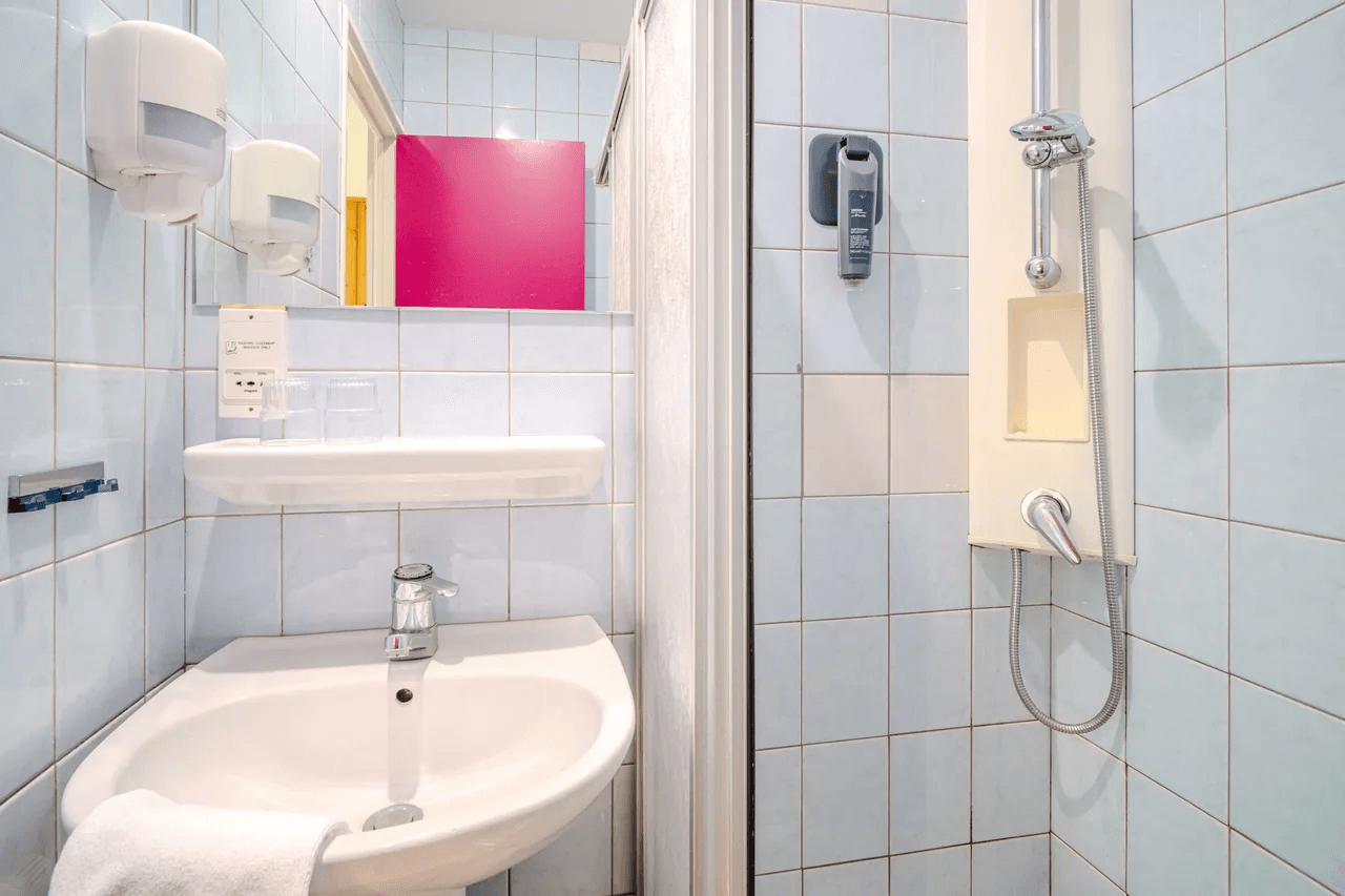 Salle de bain avec douche et lavabo — photo immobilière intérieure