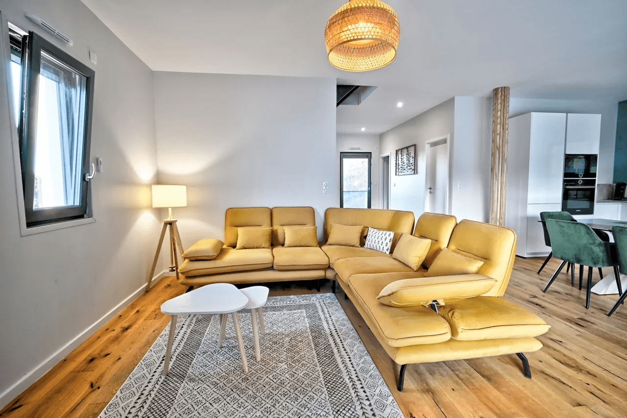 Salon moderne lumineux avec canapé jaune et baies vitrées — exemple de photo immobilière