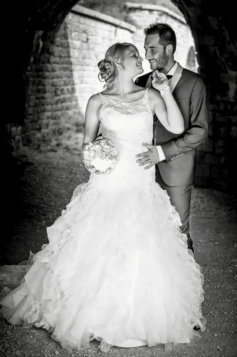 Mariés s'enlaçant sous une arche de pierre – Trash the Dress