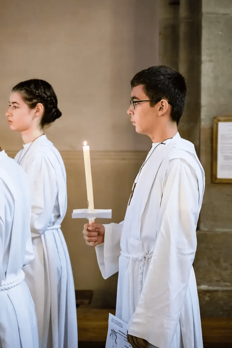 Un enfant tient une bougie allumée pendant la cérémonie