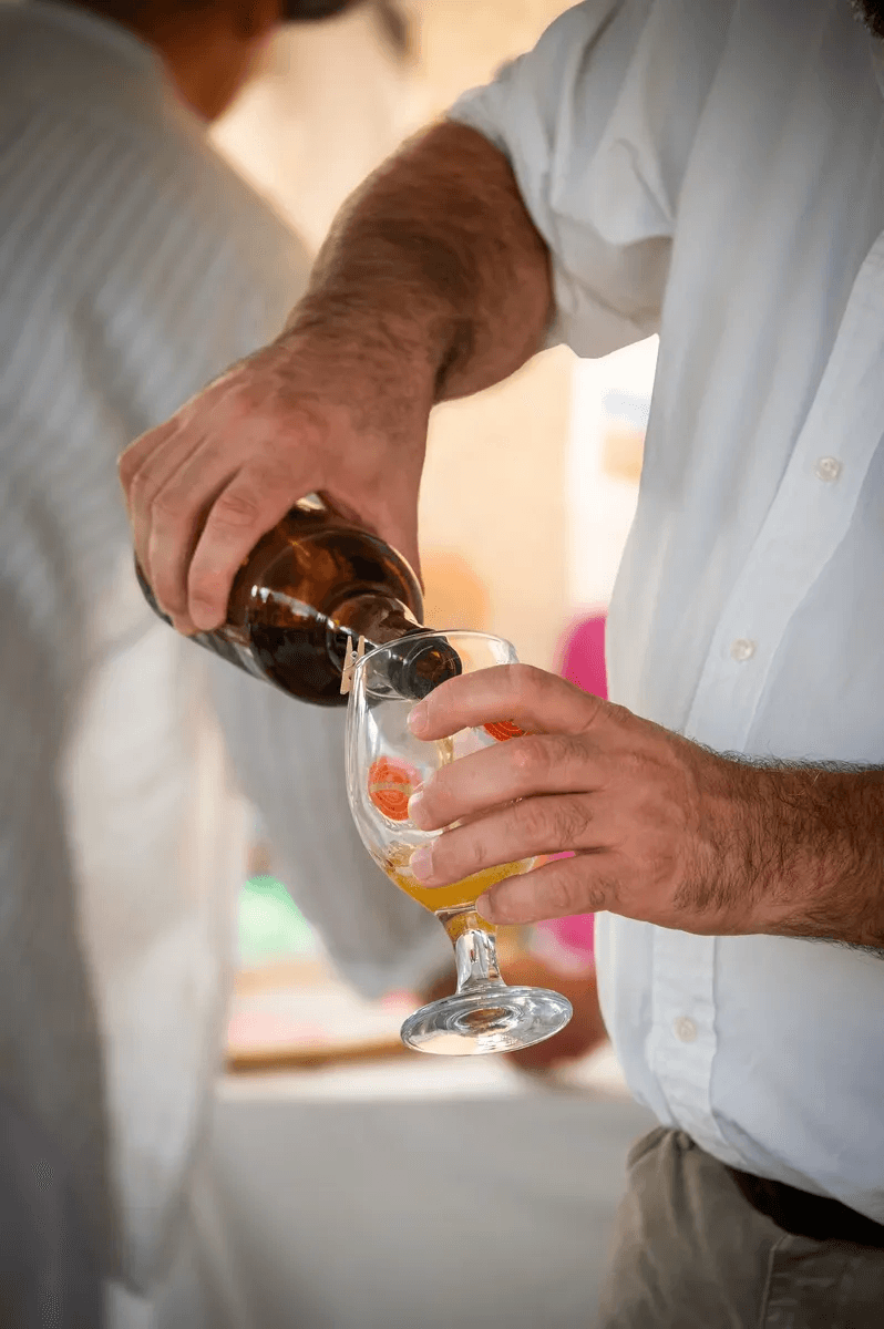 Un homme verse une boisson dans un verre lors d'un anniversaire